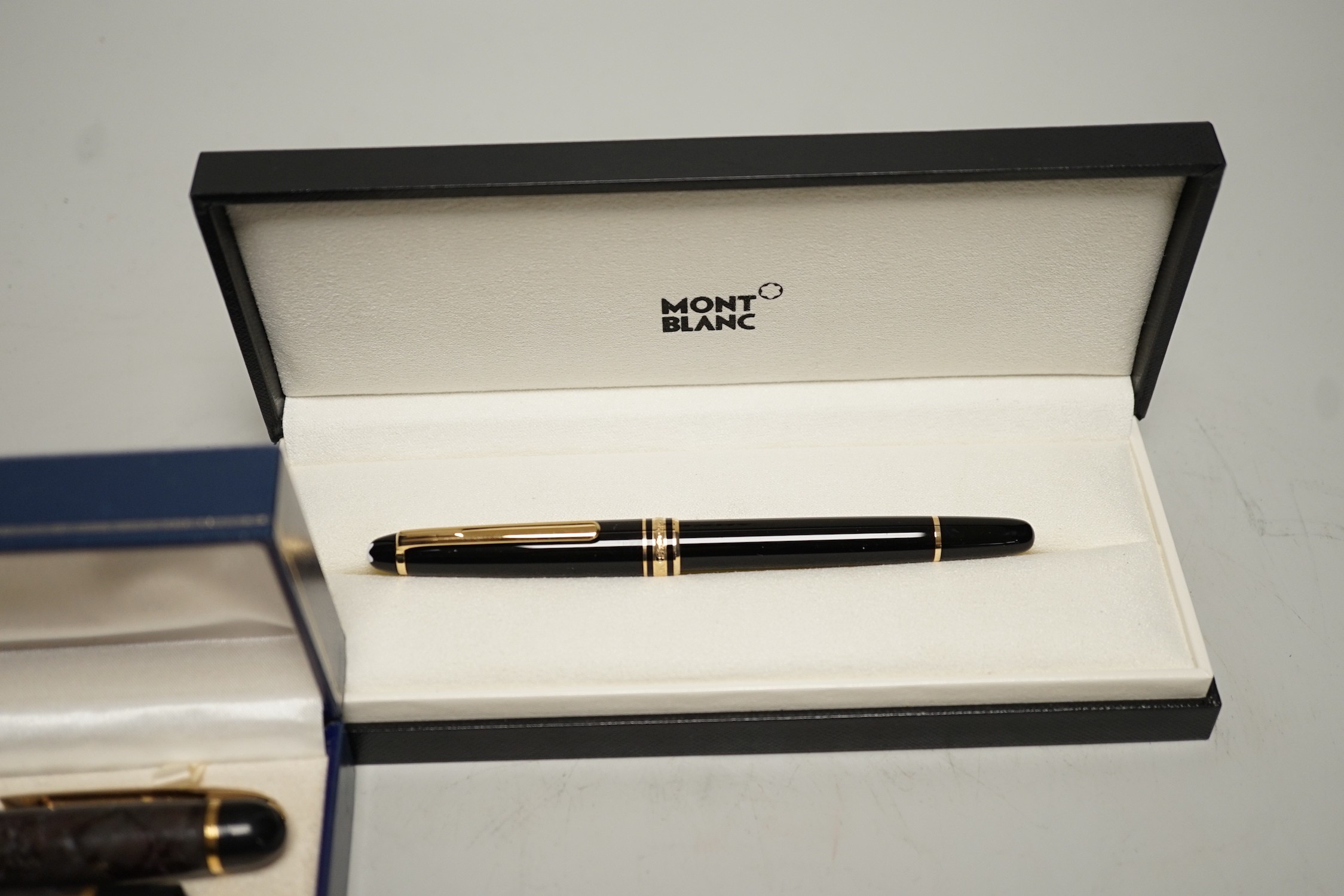 A Watermans marbled fountain pen and ballpoint pen ensuite, cased and a Montblanc ballpoint pen, cased
